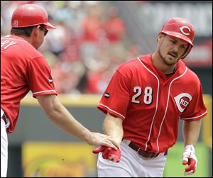 Cincinnati's Chris Heisey is congratulated by third base coach Mark Berry while rounding the bases after hitting a solo home run off Cleveland Indians starting pitcher Mitch Talbot in the second inning.