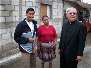 Marvin Yup, 18, his mother, Rosa Yup, meet the Rev. Vettese in the street in their neighborhood near the city dump.