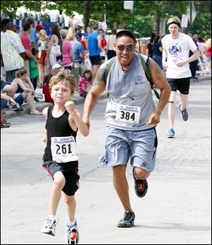 Owen Dennis, 6, of Perrysburg, gives it his all as he crosses the finish line ahead of Javier Martinez of the Marine Corps.