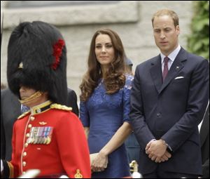 Prince William and Kate, the Duke and Duchess of Cambridge, watch an honor guard during a ceremony at Quebec City Hall.