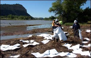 ExxonMobil contractors clean up oil along the banks of the Yellowstone River in Billings, Mont., Sunday.