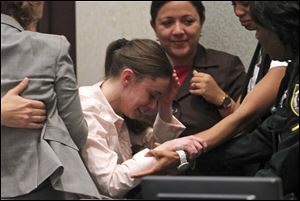 Casey Anthony, center, is overcome with emotion following her acquittal of murder charges at the Orange County Courthouse. Anthony had been charged with killing her daughter, Caylee.  
