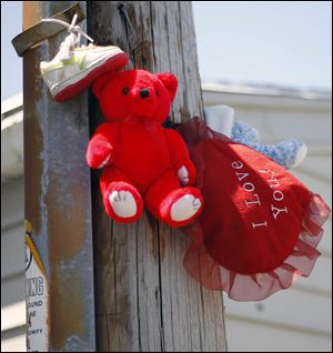 A memorial has sprung up near the site where Marquan McCuin was killed in an alley behind the 1100 block of Gordon Street early Sunday. A warrant has been issued in the case. The blade/ Amy E. Voigt