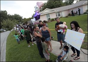 A group of neighbors and visitors stand across the street from the George and Cindy Anthony residence as most express their disagreement with the Casey Anthony verdict in Orlando, Fla. Casey Anthony was found not guilty of first-degree murder, aggravated manslaughter and aggravated child abuse. 