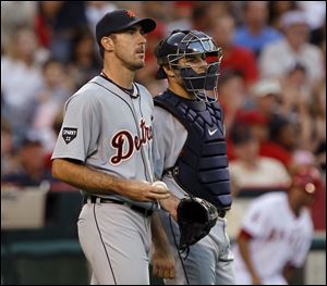 Detroit Tigers starting pitcher Justin Verlander, left, and catcher Alex Avila watch the scoreboard replay of Los Angeles Angels' Howard Kendrick scoring during the second inning Tuesday.