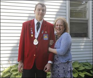 Mom Sandy Sutter smiles as son Ron Sutter displays his medals at their home. He was second in the country in a math competition sponsored by a group serving high school and college students planning technical and trade careers.