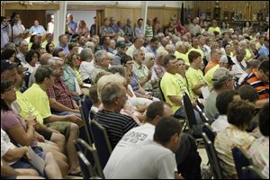 Hundreds of citizens listen to the discussion at the American Legion Post. Wind-power advocates maintain the turbines will bring cash to Riga Township, but residents fear the impact the turbines will have on their community. 