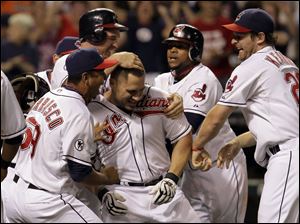 Cleveland Indians' Travis Hafner, center, is mobbed by teammates, from left, Carlos Carrasco, Jack Hannahan, Carlos Santana, and Austin Kearns after hitting a walk-off grand slam off Toronto Blue Jays' Luis Perez during the ninth inning.