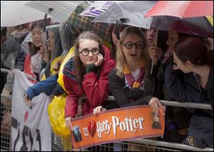 Harry Potter fans wait with umbrellas in the rain outside the cinema in Leicester Square, central London, for the world premiere of 