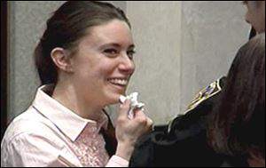 Casey Anthony smiles as she returns to the defense table Tuesday, in this image made from video, after being acquitted of murder charges at the Orange County Courthouse in Orlando, Fla.