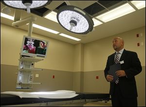 Sean Tucker, from medical device firm Steris Corp., demonstrates lighting equipment at Wildwood Orthopaedic and Spine Hospital.