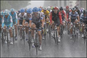The lead pack of cyclists rides in pouring rain Thursday during the sixth stage of the Tour de France.