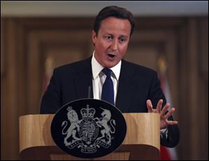 Britain's Prime Minister David Cameron during a press conference Friday in London promised a full investigation into the phone hacking and the police bribery that lead to the collapse of the News of the World tabloid, saying that British politicians had for too long looked the other way at illegal practices.