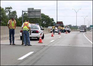 Ohio Department of Transportation workers examine the I-75 bridge joint at Lagrange Street.
