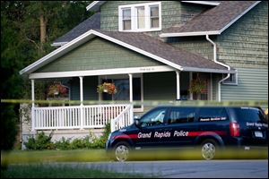 Police investigate a home where three bodies were discovered from a shooting rampage Thursday in Grand Rapids, Mich. 