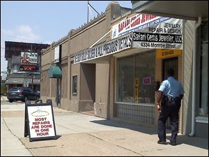 A police officer is on the scene of a robbery Friday at Safari Gems on Monroe Street.