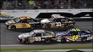 Jeff Burton (31), Clint Bowyer (33), Dale Earnhardt Jr. (88) and Jimmie Johnson (48) compete in the  NASCAR Coke Zero 400 auto race at Daytona International Speedway in Daytona Beach, Fla.
