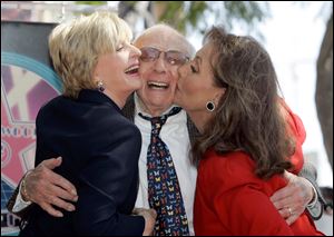 Writer/producer Sherwood Schwartz receives a kiss from actresses Florence Henderson, left, and Dawn Wells during a ceremony where Schwartz was honored with a star on the Hollywood Walk of Fame in Los Angeles, in this March 7, 2008 file photo.