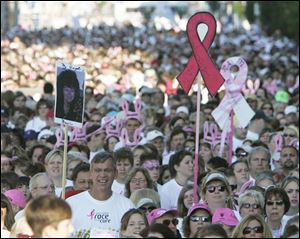 Walkers hold signs as they start the Susan G. Komen Race for the Cure in Toledo in this Sept. 28, 2008, file photo.