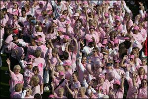 Breast cancer survivors wave to the crowd as they form a human pink ribbon at Fifth Third Field following the Susan G. Komen Race for the Cure in Toledo in this Sept. 28, 2008, file photo.