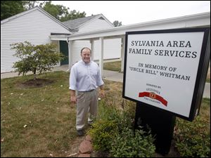 Jason Robertson, the executive director of the Sylvania Area Family Services, stands in front of the building that will be torn down and replaced where a new $500,000 building expansion will be.