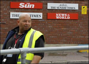 A security guard keeps watch Thursday at News International in Wapping, London.