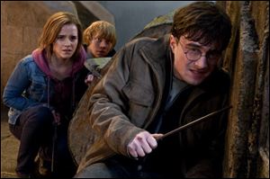 Emma Watson, Rupert Grint, and Daniel Radcliffe are shown in a scene from 