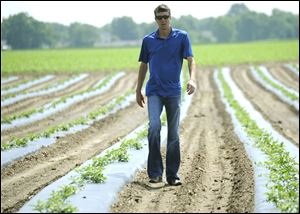 Braden Janowski walks through a watermelon field in Niles, Mich. The 33-year-old software executive from Tulsa successfully bid  $4 million for the 430-acre farm at auction. He is among a growing number of rich investors with no ties to farming who are confident enough to wager on a patch of earth.