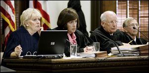 Ohio Supreme Court Justices Judith Lanzinger, left, and Paul Pfeifer, right, could not run again unless the mandatory retirement age is raised or lifted. Between them during a 2009 hearing was Justice Maureen O’Connor, now the court’s chief justice.