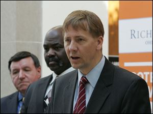 Attorney General Richard Cordray, right, speaks about the rise of consumer fraud complaints rising statewide at the Main Branch of the Toledo-Lucas County Public Library in this March 8, 2010, file photo. Looking on are Toledo Mayor Mike Bell, center, and Richard Eppstein, president of the local Better Business Bureau.