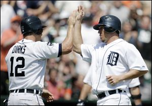 Detroit Tigers' Andy Dirks (12) and Magglio Ordonez celebrate after scoring during the sixth inning against the Chicago White Sox, Sunday.