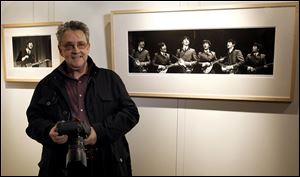 Photographer Mike Mitchell with some of his photographs of The Beatles on exhibit at a hotel in London.