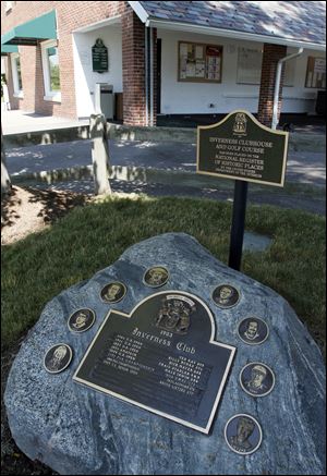 The rock at Inverness Club sits next to a sing noting the club as part of the National Register of Historic Places.