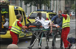 A victim is carried to a waiting ambulance in central Oslo.