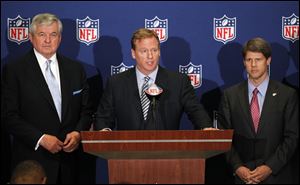 NFL football commissioner Roger Goodell, center, announces that NFL owners have agreed to a tentative agreement that would end the lockout pending the players approval. Carolina Panthers owner Jerry Richardson, left, and Kansas City Chiefs owner Clark Hunt look on.