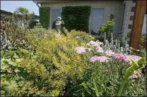 The courtyard in front of the house at Fox Fire Farm has four sections, each planted with perennials and incorporating a piece of art.