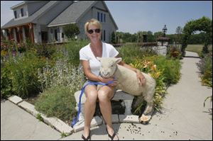 Fae Leffler and Amore, a 4-month-old lamb, in the courtyard garden.