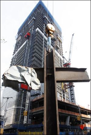 The September 11 cross stands in front of 4 World Trade Center during a ceremony, Saturday, July 23, 2011, in New York. After the ceremony, the cross was installed at the National September 11 Memorial and Museum. It was discovered upright in the ruins of ground zero following the attacks of Sept. 11, 2001.