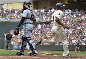 Minnesota Twins' Ben Revere, right, scores behind Detroit Tigers catcher Alex Avila, left, on a single by the Michael Cuddyer during the first inning Saturday.