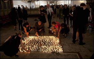 People light candles after a service at Oslo Cathedral in the aftermath of the attacks on Norway's government headquarters and a youth retreat in Oslo, Sunday.