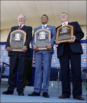 Pat Gillick, left, Roberto Alomar, center, and Bert Blyleven hold their plaques after their induction into the Baseball Hall of Fame in Cooperstown, N.Y., on Sunday.