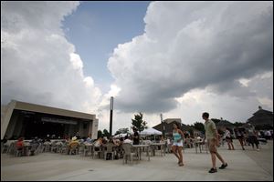 Storm clouds move over the Northwest Ohio Pizza Palooza at Centennial Terrace in Sylvania Township. Brian Easterling of Amie's Pizza, one of the participating businesses, said the event was suspended half an hour at most during last night's storm.