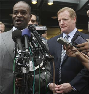 DeMaurice Smith of the players' union speaks after the lockout ended as Commissioner Roger Goodell listens.
