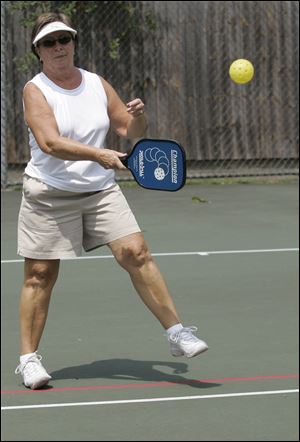 Ginger Goodin plays pickleball on a redesigned tennis court in Petersburg. The game, similar to tennis, is popular in Florida and gaining fans across the local region.