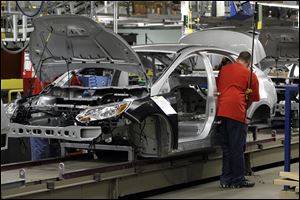 A line worker assembles a 2012 Ford Focus at the Michigan Assembly Plant in Wayne, Mich. 