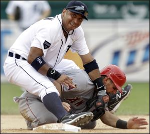 Detroit Tigers second baseman Carlos Guillen lands on Los Angeles Angels' Jeff Mathis at second base after throwing to first base on a Erick Aybar fielder's choice in the seventh inning Thursday.