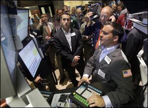 Traders gather on the floor of the New York Stock Exchange, where jitters over a possible U.S. default and a bad economy were evident.