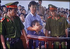 This image from TV shows a security officer silencing the Rev. Nguyen Van Ly after the priest yelled out ‘Communist court.’