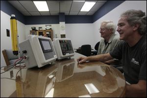 Rob Nutter and Jim Schroeder Sr. look at a temperature control device at Seagate Control Systems.