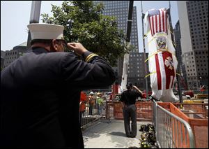 Firefighters and other guests salute as the Fire Department of New York's Ladder Company 3 fire truck is lowered by crane into the National September 11 Memorial Museum in New York. This fire truck was used to evacuate people from the World Trade Center towers during the terror attacks on Sept. 11, 2001. 